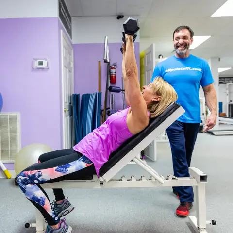 Tim spotting a client through an incline dumbbell press