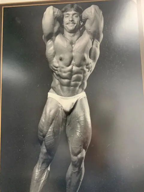 Tim Underwood on stage in a bodybuilding competition, black and white photo